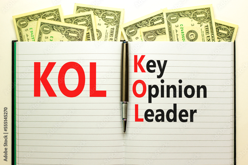 KOL key opinion leader symbol. Concept words KOL key opinion leader on white note on a beautiful background from dollar bills. Business KOL key opinion leader concept. Copy space. KOL key opinion leader symbol. Concept words KOL key opinion leader on white note on a beautiful background from dollar bills. Business KOL key opinion leader concept. Copy space.