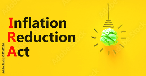 IRA inflation reduction act symbol. Concept words IRA inflation reduction act on yellow paper on beautiful yellow background. Light bulb icon. Business IRA inflation reduction act concept. Copy space. photo