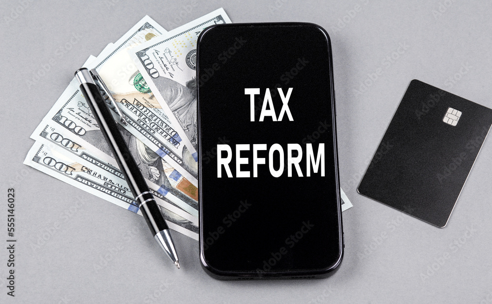 Credit card and text TAX REFORM on smartphone with dollars and pen. Business concept Credit card and text TAX REFORM on smartphone with dollars and pen. Business concept