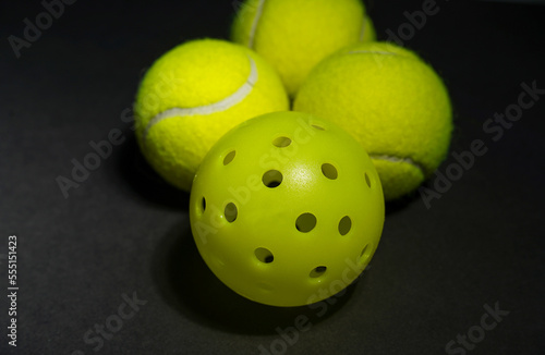 pickle balls with tennis balls on black background