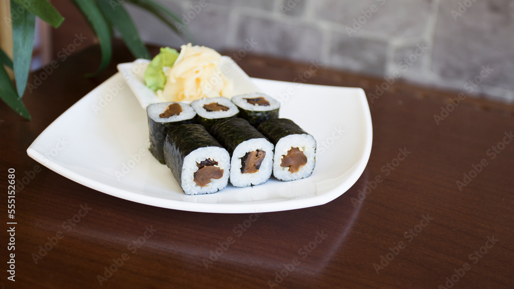 Vegan Maki sushi with rice and seaweed stuffed with vegetables and vegetarian ingredients.