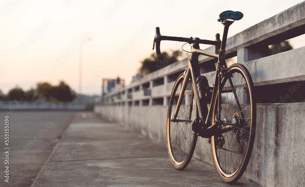 Road bike parked on a beautiful road sunset, warm light with copy space. Road bike parked on a beautiful road sunset, warm light with copy space.