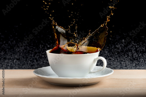 black coffee splashing in white cup for dark background