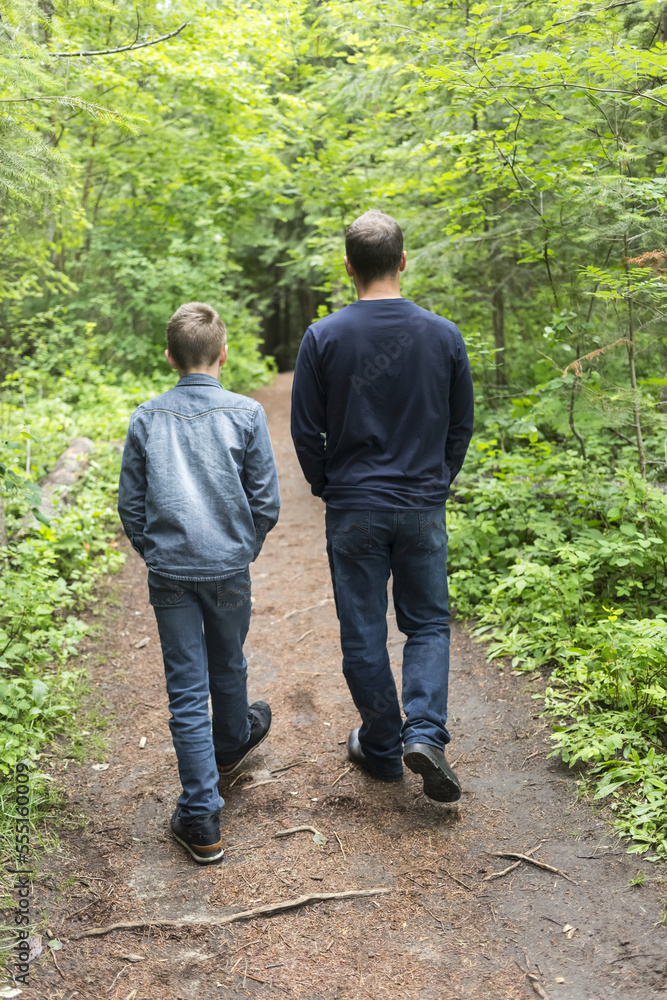 Father and son walking together on a trail; Salmon Arm, British Columbia, Canada Father and son walking together on a trail; Salmon Arm, British Columbia, Canada