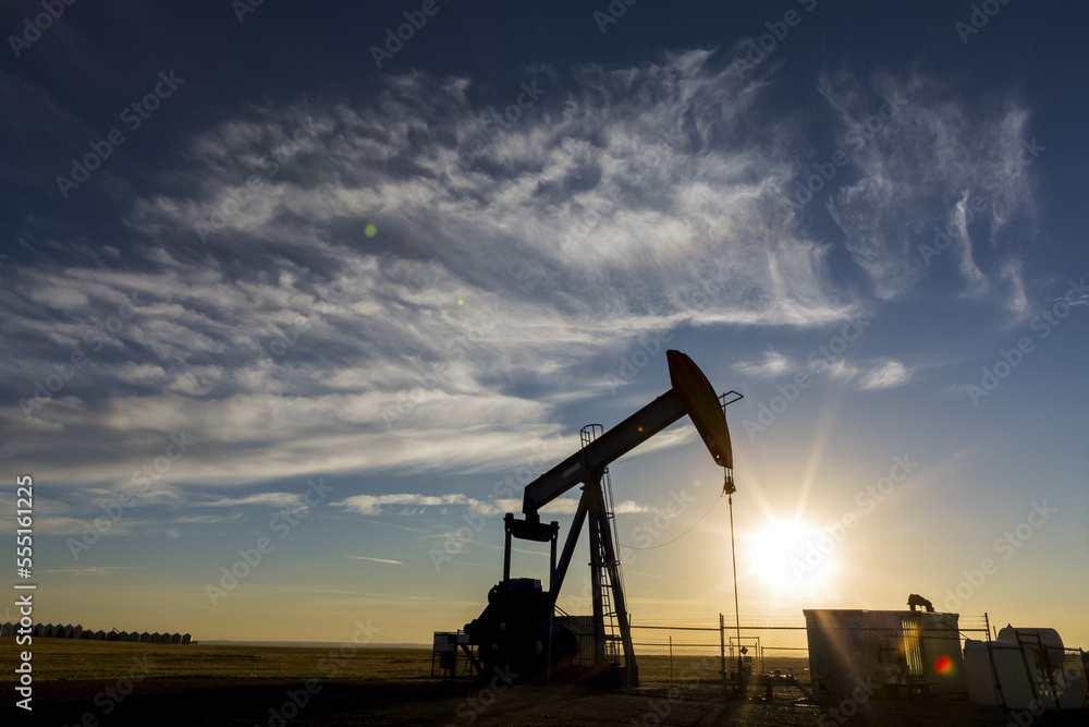Silhouette of a pumpjack with sunburst at sunrise, West of Airdrie; Alberta, Canada Silhouette of a pumpjack with sunburst at sunrise, West of Airdrie; Alberta, Canada