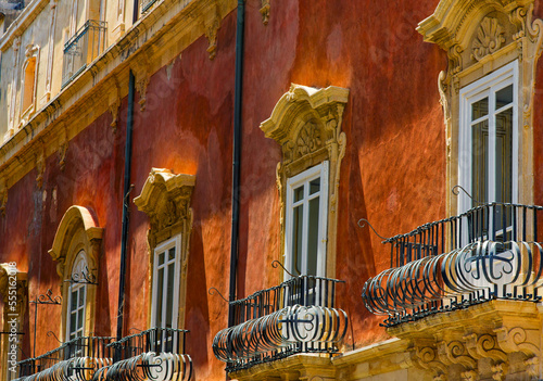 Facade of a residential building with ornate balconies and corbels; Syracuse, Sicily, Ortigia, Italy photo