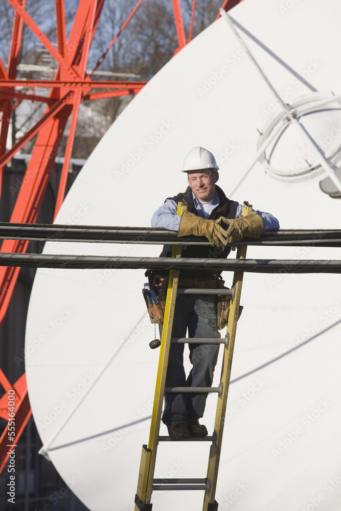 Cable lineman standing on a ladder to repair transmission line Cable lineman standing on a ladder to repair transmission line