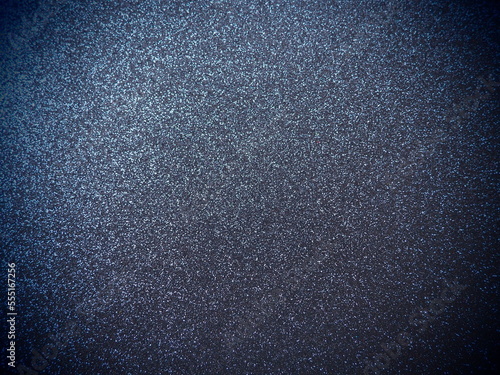 Deep blue shiny bokeh abstract background. Blue - black paper with sparkles. Festive backdrop with dark vignette
