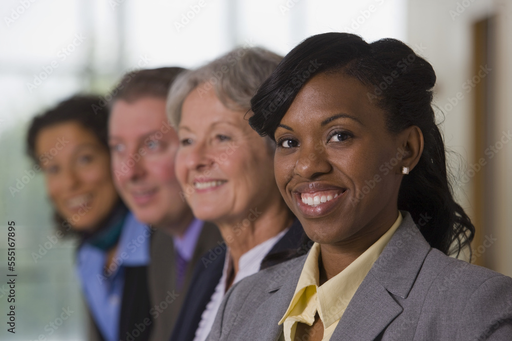 Team of business people with three business women and one business man standing in a row Team of business people with three business women and one business man standing in a row