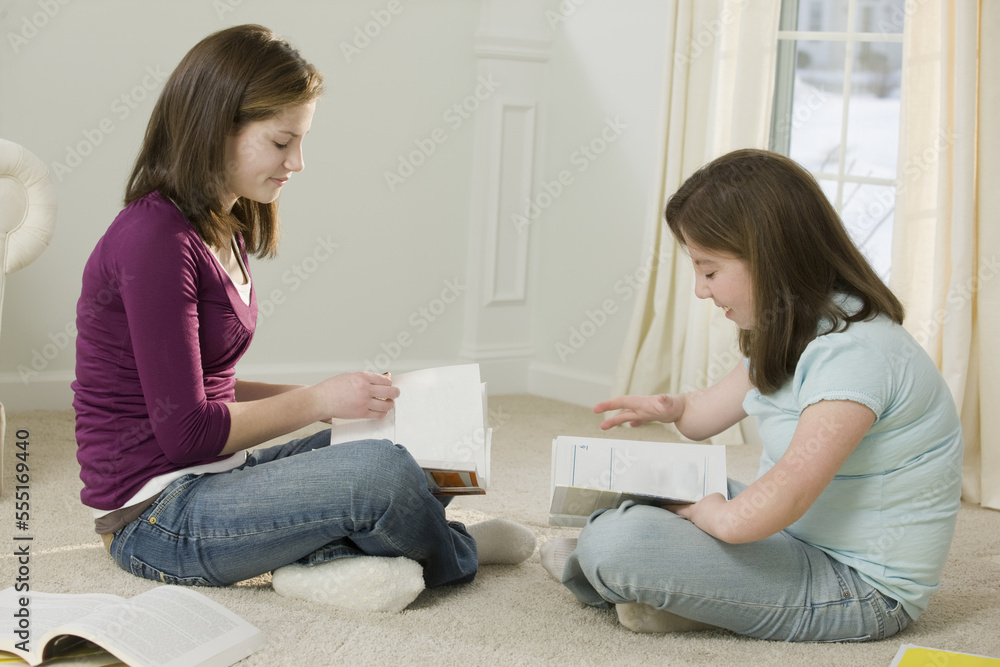 Two teenage girls studying together, one with birth defect Two teenage girls studying together, one with birth defect