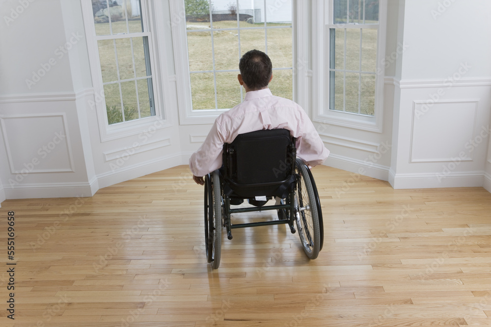 Rear view of a man sitting in a wheelchair Rear view of a man sitting in a wheelchair