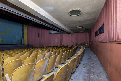 A old retro cinema hall with red fabric on the walls.