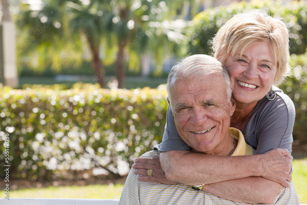 Portrait of a senior woman hugging a senior man from behind Portrait of a senior woman hugging a senior man from behind