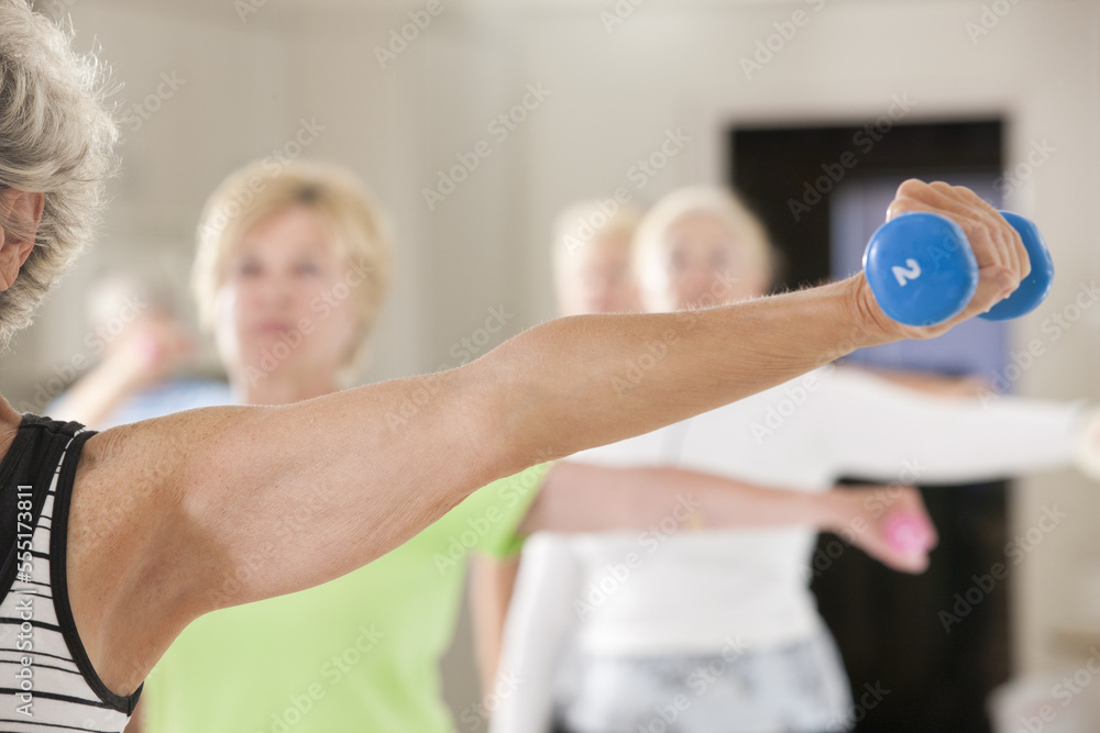 Seniors exercising with dumbbells in a health club