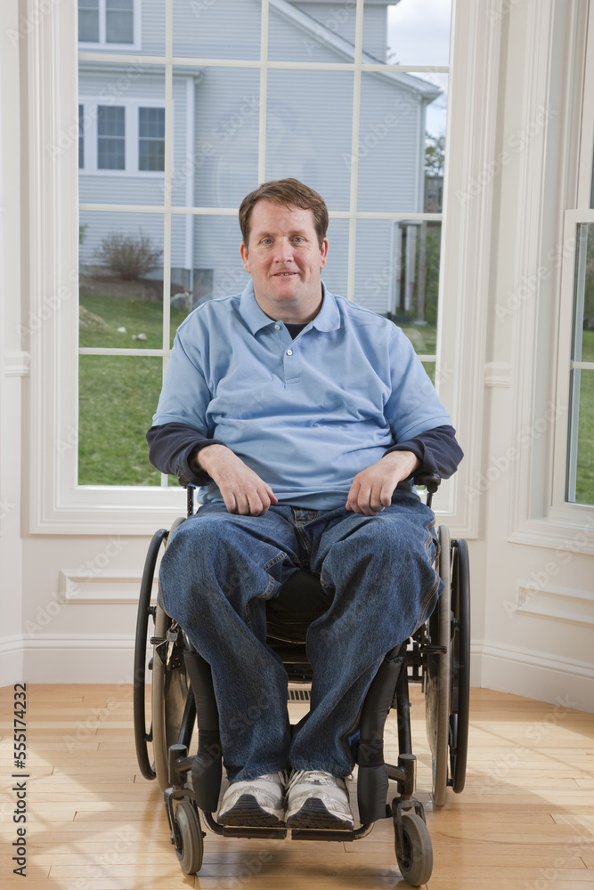 Man with spinal cord injury in a wheelchair smiling in his accessible home Man with spinal cord injury in a wheelchair smiling in his accessible home