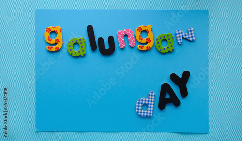 Galungan day fiesta balinesa con letras en fondo azul photo