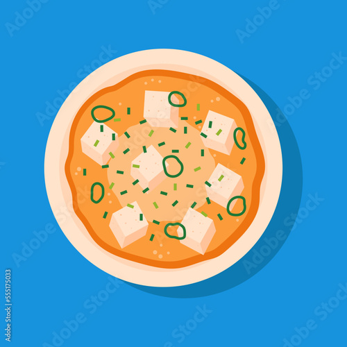 Miso soup with tofu and green onions. Traditional Japanese soup on blue background.