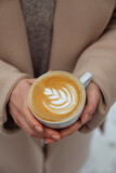 Girl holds a cup of cappuccino