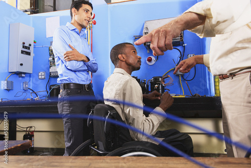 Instructor discussing condenser coil on refrigeration unit with student in wheelchair photo