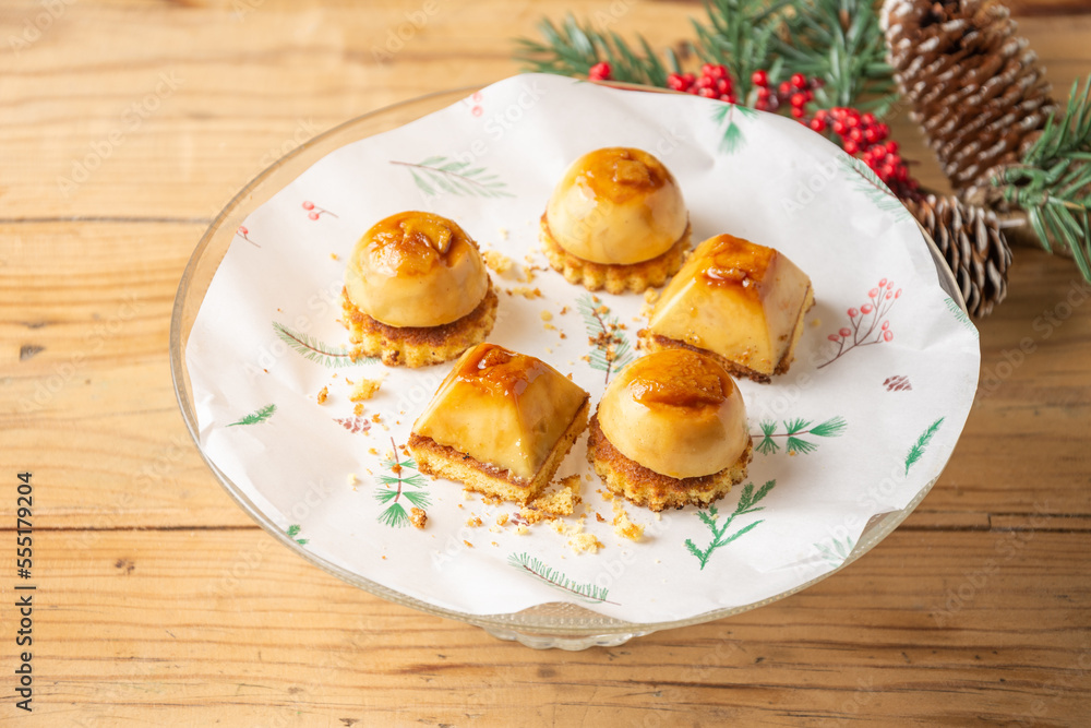 Top view of cream cakes with biscuit on plate and wooden table with Christmas decorations, horizontal, with copy space Top view of cream cakes with biscuit on plate and wooden table with Christmas decorations, horizontal, with copy space
