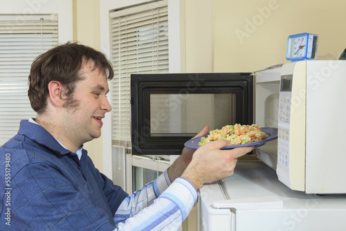 Man with Asperger's living in his home and cooking in microwave photo