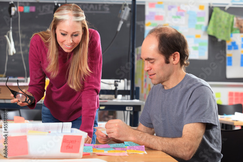 Engineering students reviewing brainstorming notes in lab, the man with Aspergers