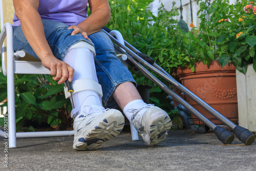 Woman with Spina Bifida adjusting leg brace so she can walk photo