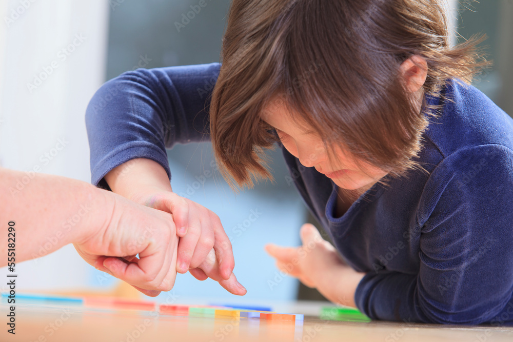 Little girl with Down Syndrome playing a learning game with her Mom Little girl with Down Syndrome playing a learning game with her Mom