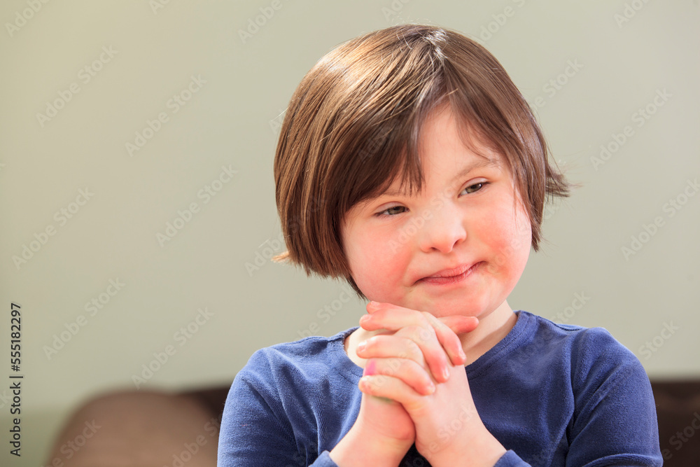 Little girl with Down Syndrome clasping her hands Little girl with Down Syndrome clasping her hands