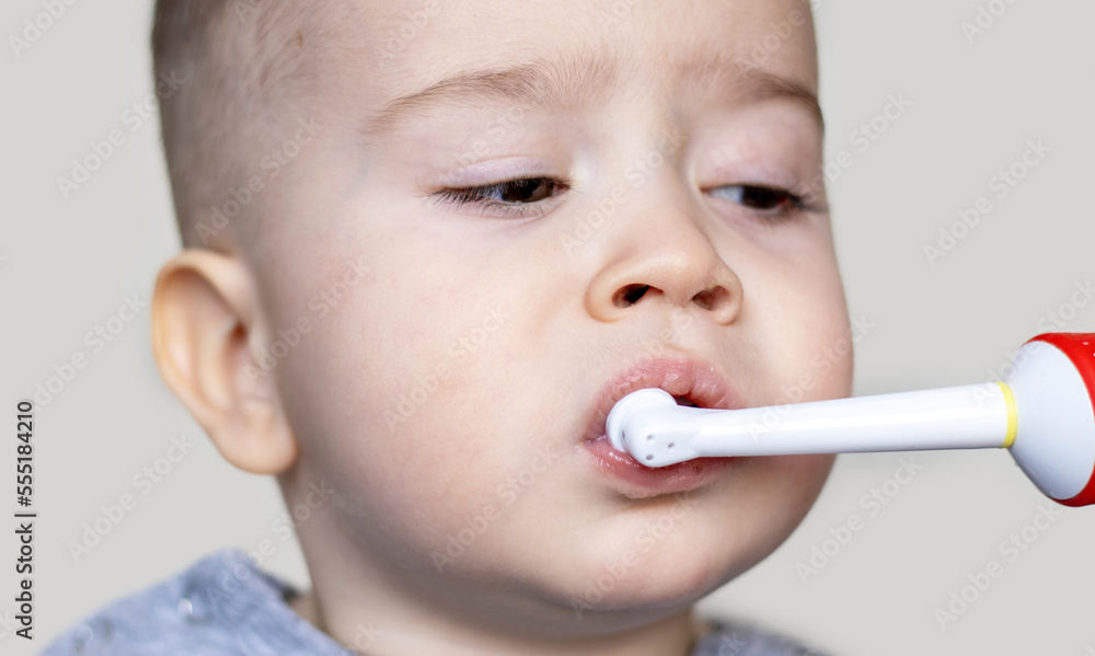 portrait of kid little boy child baby toddler infant brushing milk teeth with electric toothbrush isolated dental daily care hygiene routine mouth cavity.dentistry doctor caries tartar prevention portrait of kid little boy child baby toddler infant brushing milk teeth with electric toothbrush isolated dental daily care hygiene routine mouth cavity.dentistry doctor caries tartar prevention