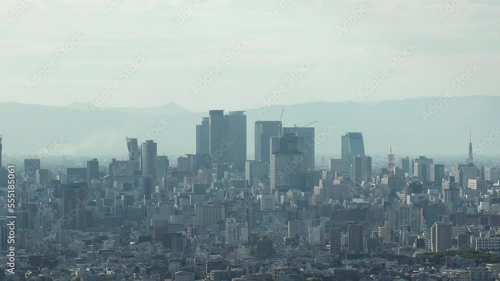 NAGOYA, JAPAN - OCTOBER 2022 : Aerial high angle view of NAGOYA CITY in sunny daytime. View of buildings and street traffic around Nagoya station and Sakae area (central downtown). Time lapse shot. NAGOYA, JAPAN - OCTOBER 2022 : Aerial high angle view of NAGOYA CITY in sunny daytime. View of buildings and street traffic around Nagoya station and Sakae area (central downtown). Time lapse shot.