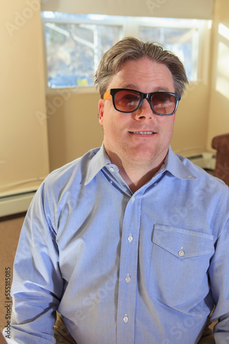 Man with congenital blindness sitting in his living room photo