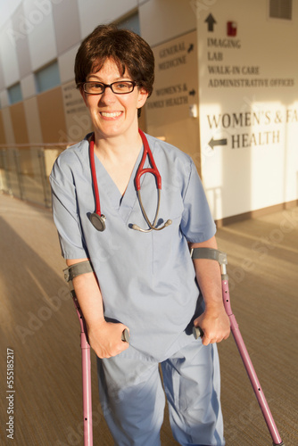 Nurse with Cerebral Palsy walking down the hallway of a clinic with her canes photo