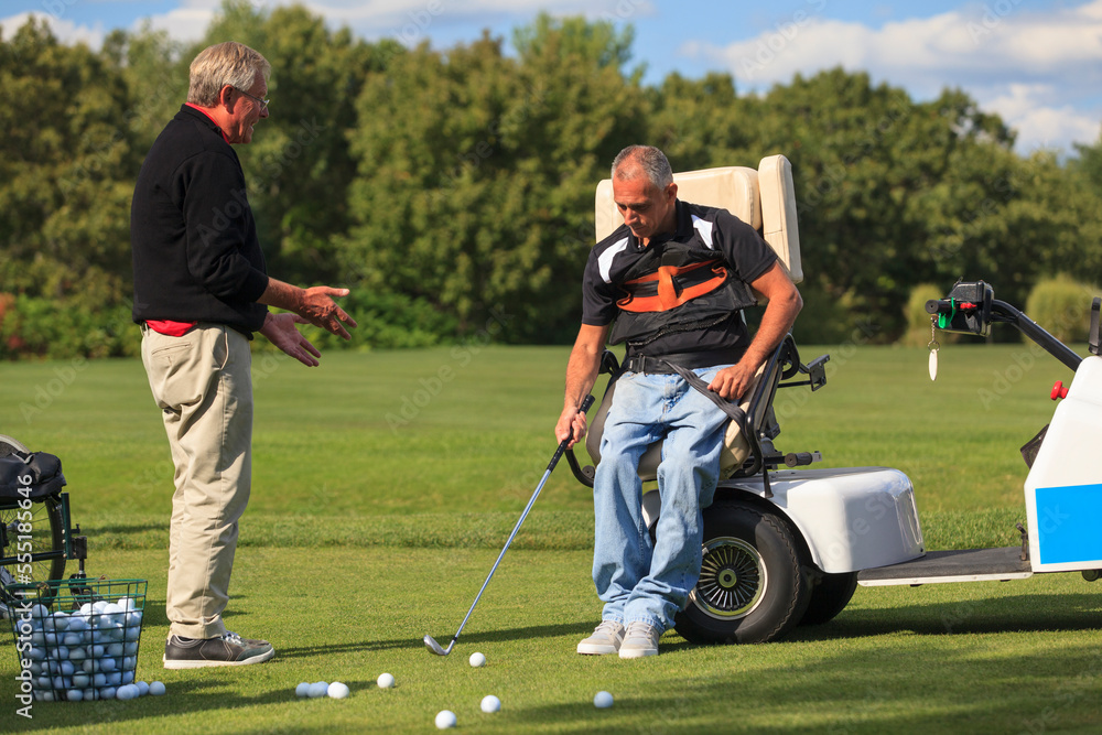 Instructor helping a Man with spinal cord injury to learn golf Instructor helping a Man with spinal cord injury to learn golf