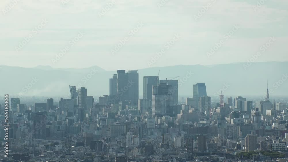 NAGOYA, JAPAN - OCTOBER 2022 : Aerial high angle view of NAGOYA CITY in sunny daytime. View of buildings and street traffic around Nagoya station and Sakae area (central downtown). Time lapse shot. NAGOYA, JAPAN - OCTOBER 2022 : Aerial high angle view of NAGOYA CITY in sunny daytime. View of buildings and street traffic around Nagoya station and Sakae area (central downtown). Time lapse shot.