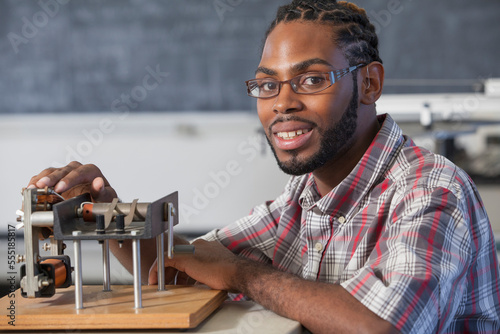 Student who had Spinal Meningitis and with hearing impairment working on an electromagnetism experiment in laboratory