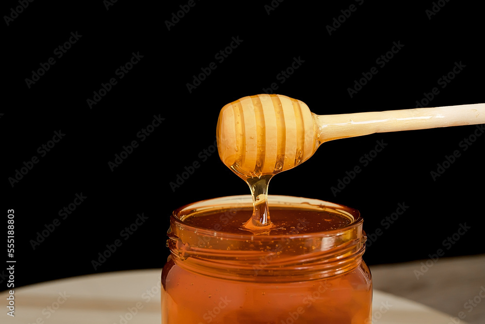 Spoon of honey. On a black background. Dripping fresh honey. Spoon of honey. On a black background. Dripping fresh honey.