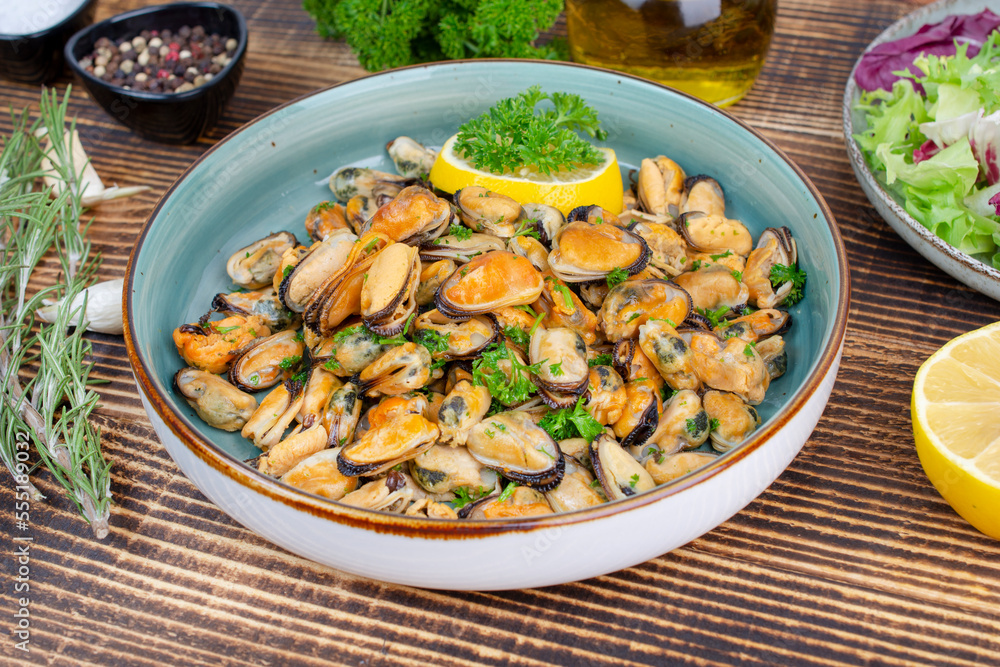 Mussels in wine with parsley and lemon. Seafood. Delicious snack for gourmands. Close up Mussels in wine with parsley and lemon. Seafood. Delicious snack for gourmands. Close up