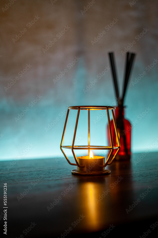 Close-up of a cozy candle inside a metal holder on a wooden table