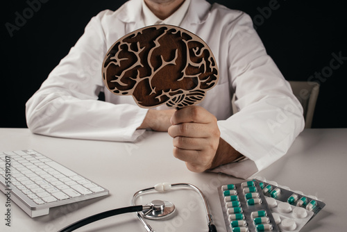 Doctor holding wooden brain model. Awareness of Alzheimer's, Parkinson's disease, dementia