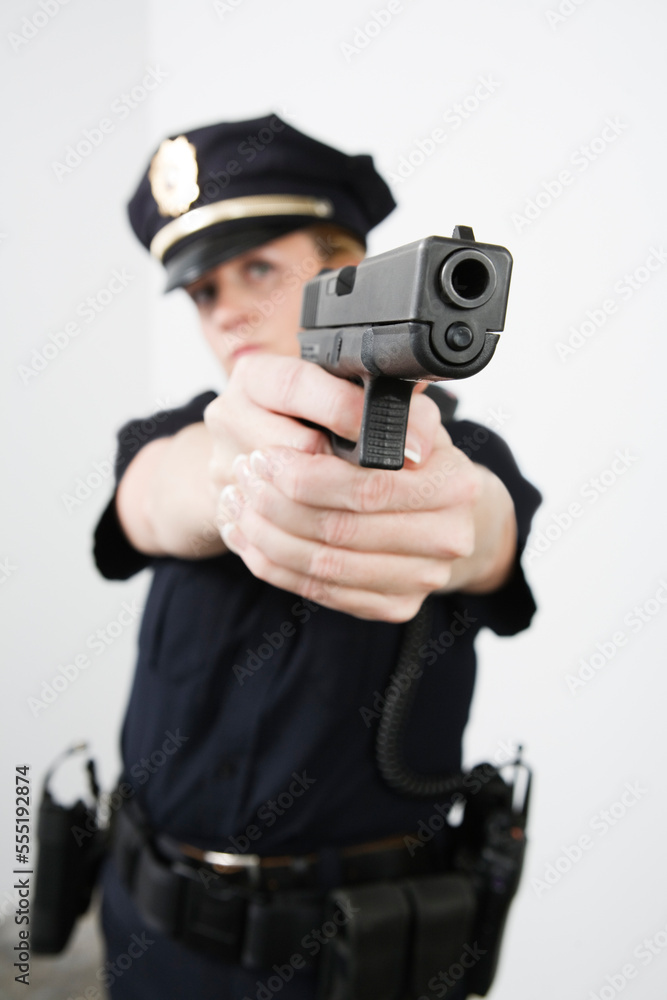 View of a police woman aiming with pistol. View of a police woman aiming with pistol.