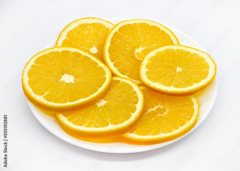 Sliced orange slices on a white plate. Orange slices on a white background. Oranges close-up. Sliced orange slices on a white plate. Orange slices on a white background. Oranges close-up.