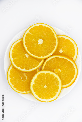 Sliced orange slices on a white plate. Orange slices on a white background. Oranges close-up.