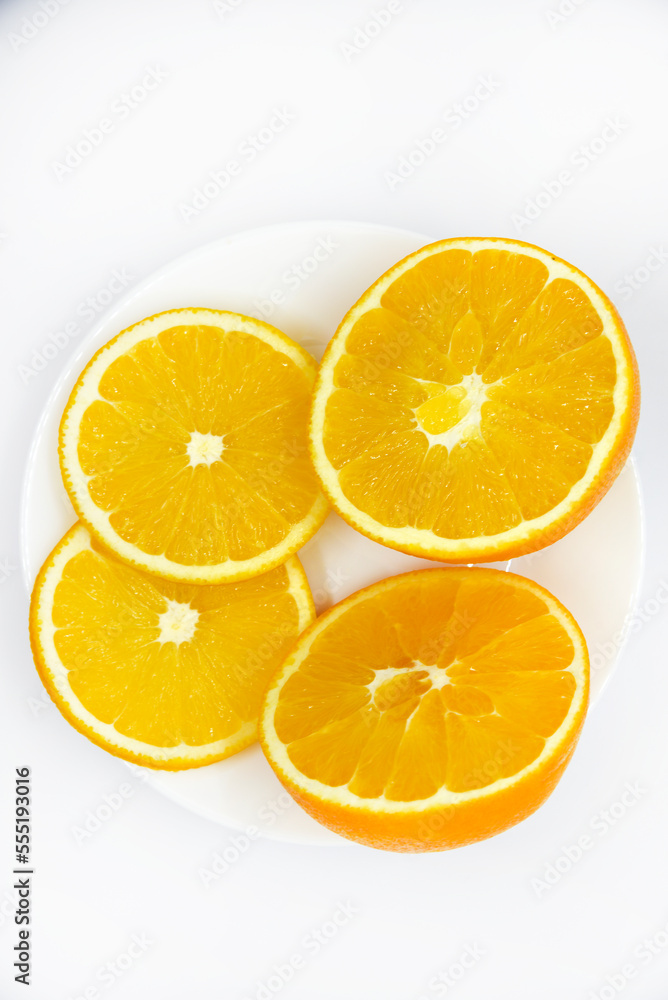 Sliced orange slices on a white plate. Orange slices on a white background. Oranges close-up. Sliced orange slices on a white plate. Orange slices on a white background. Oranges close-up.