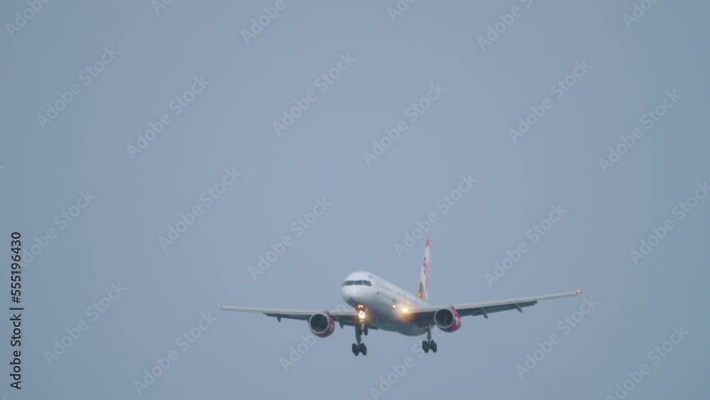 Front view of Jet airplane landing at Phuket Airport. Airliner arrival, flies past trees. Tourism and travel concept Front view of Jet airplane landing at Phuket Airport. Airliner arrival, flies past trees. Tourism and travel concept