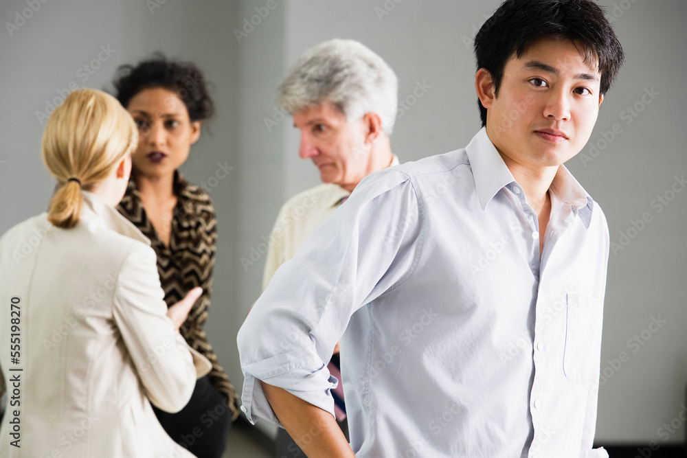 Portrait of business man with colleagues in background. Portrait of business man with colleagues in background.