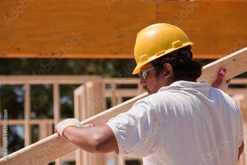 Carpenter carrying a wall stud photo