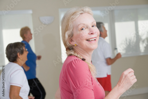 Side profile of a senior woman exercising in a gym and smiling photo