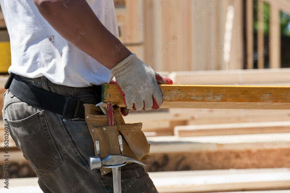 Carpenter lifting a laminated beam Carpenter lifting a laminated beam