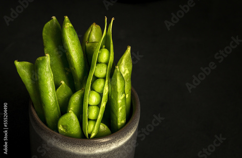 Pot with pea pods in studio photo